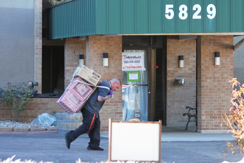 A mover hauls a load out of the Windermere apartment tower on Dec. 15.